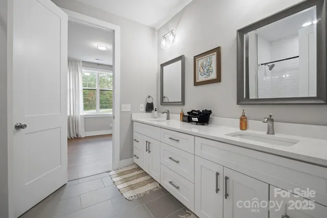 a bathroom with a double vanity sink a mirror and a bathtub