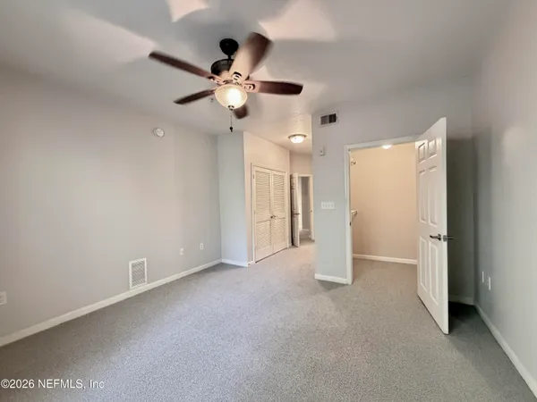a view of an empty room with a ceiling fan