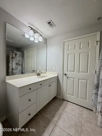 a spacious bathroom with a granite countertop sink and a mirror