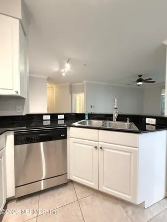 a kitchen with granite countertop white cabinets and white appliances