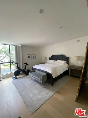 a bedroom with a bed and large windows