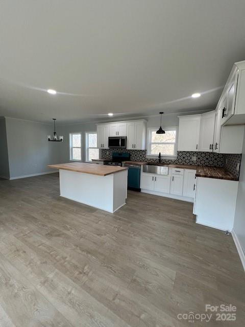5949 Flat Creek Road Kershaw, SC 29067 - Photo 9 of 20 a large white kitchen with kitchen island a stove a sink a refrigerator and white cabinets