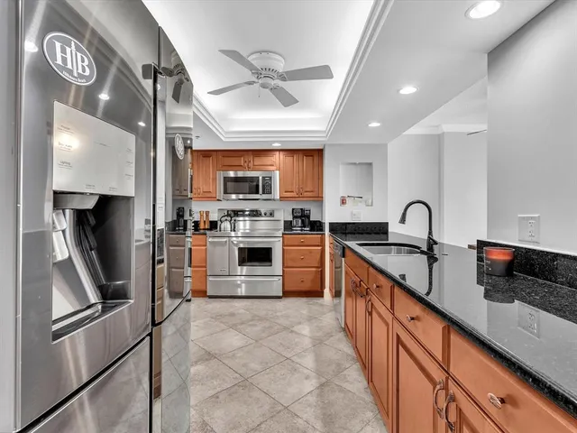 a kitchen with granite countertop a stove top oven microwave and cabinets