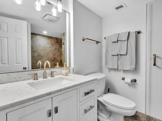 a bathroom with a double vanity sink mirror and toilet