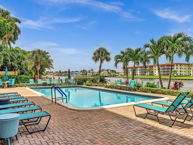 a view of a roof deck with couches and wooden fence
