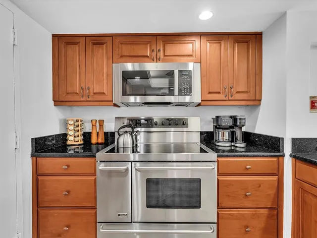 a kitchen with stainless steel appliances granite countertop a refrigerator and a sink