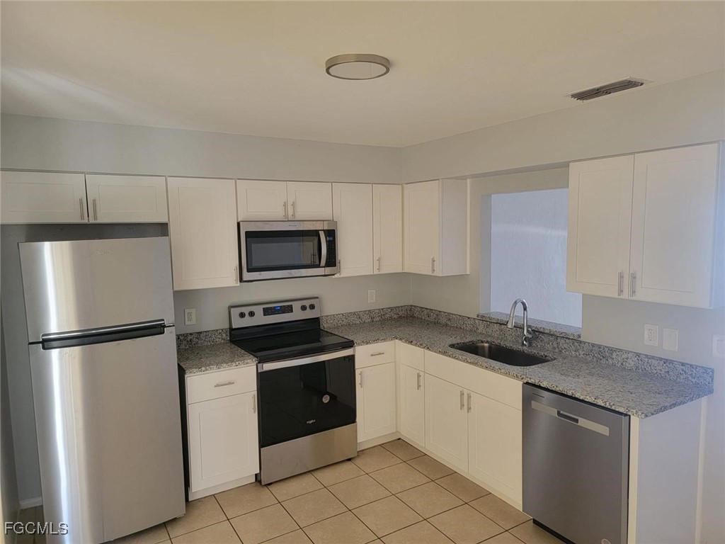3165 East Riverside Drive, Unit 3175 Fort Myers, FL 33916 - Photo 1 of 8 a kitchen with a stove a refrigerator and a sink