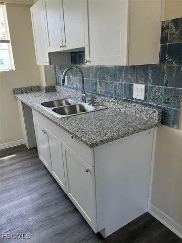 a kitchen with granite countertop a sink and a stove