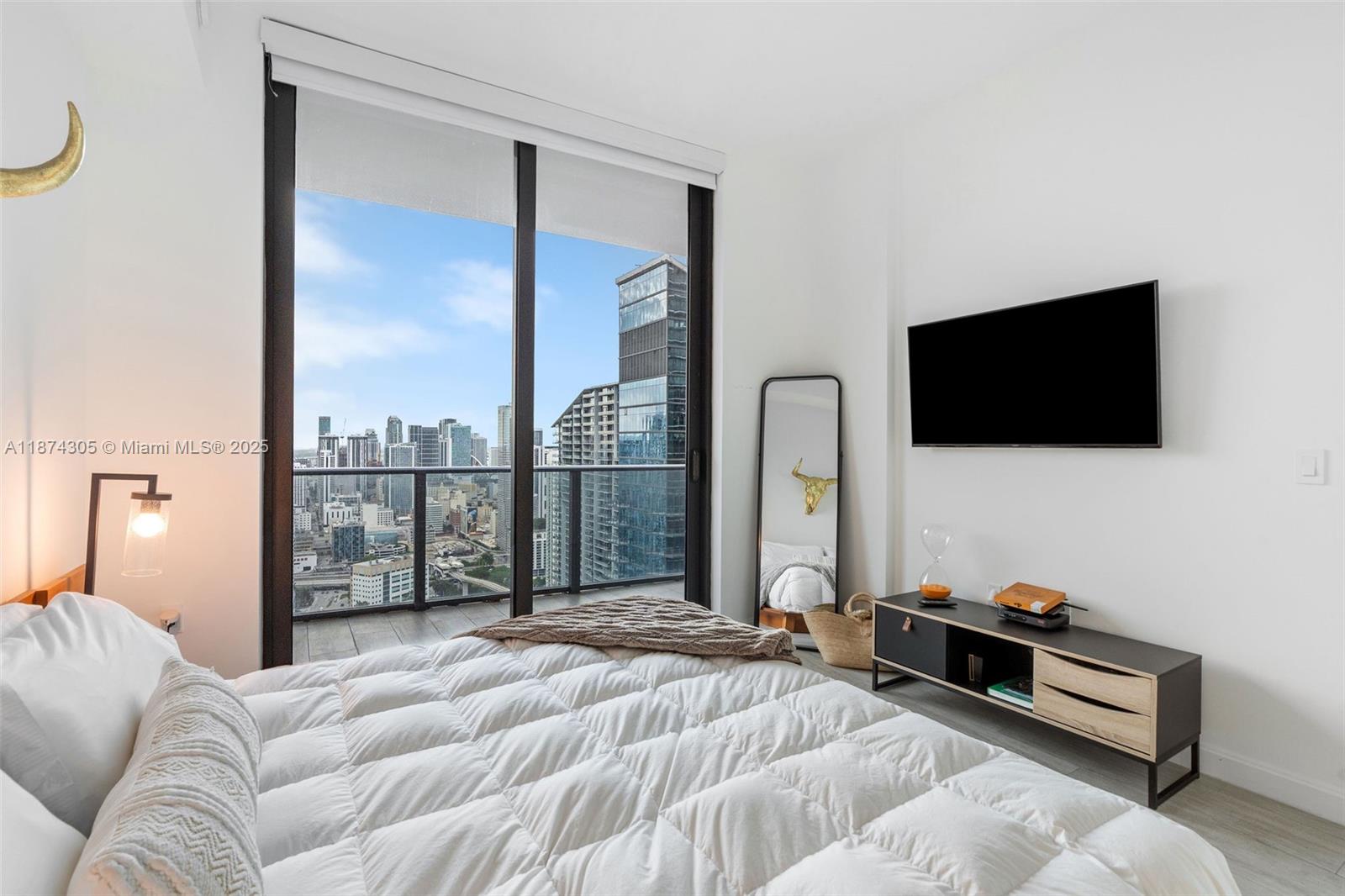 45 Southwest 9th Street, Unit 4301 Miami, FL 33130 - Photo 13 of 30 a bedroom with a bed and a flat screen tv