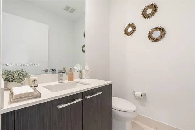 a bathroom with a sink vanity mirror and toilet
