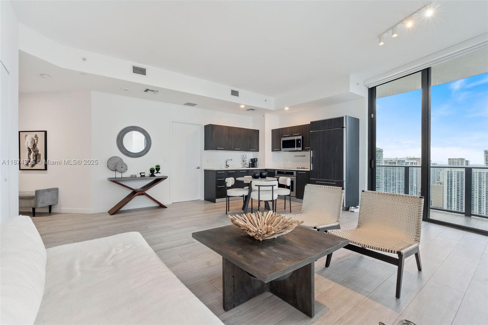 45 Southwest 9th Street, Unit 4301 Miami, FL 33130 - Photo 3 of 30 a living room with furniture a dining table and a floor to ceiling window