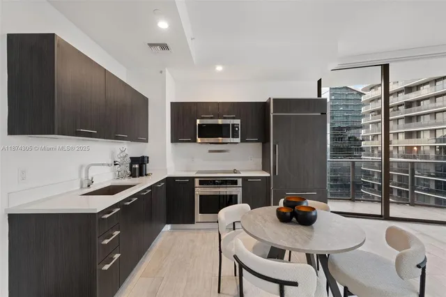 a kitchen with stainless steel appliances a stove a sink a microwave a refrigerator and cabinets