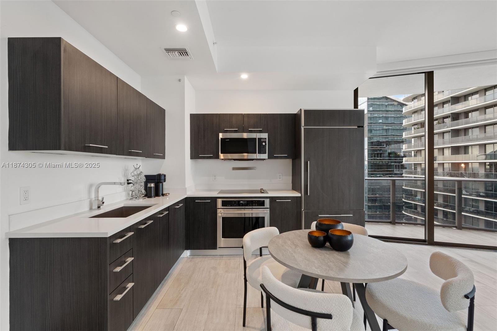 45 Southwest 9th Street, Unit 4301 Miami, FL 33130 - Photo 6 of 30 a kitchen with stainless steel appliances a stove a sink a microwave a refrigerator and cabinets