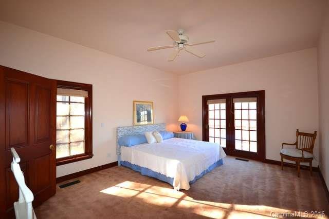 969 Hunting Country Road Tryon, NC 28782 - Photo 12 of 23 a bedroom with a bed and wooden floor