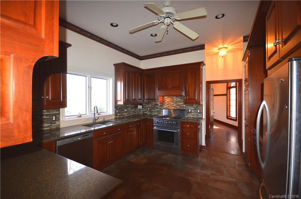969 Hunting Country Road Tryon, NC 28782 - Photo 8 of 23 a kitchen with stainless steel appliances granite countertop a refrigerator a stove and a sink with large window