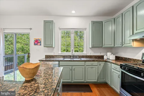a kitchen with kitchen island granite countertop a sink and a stove