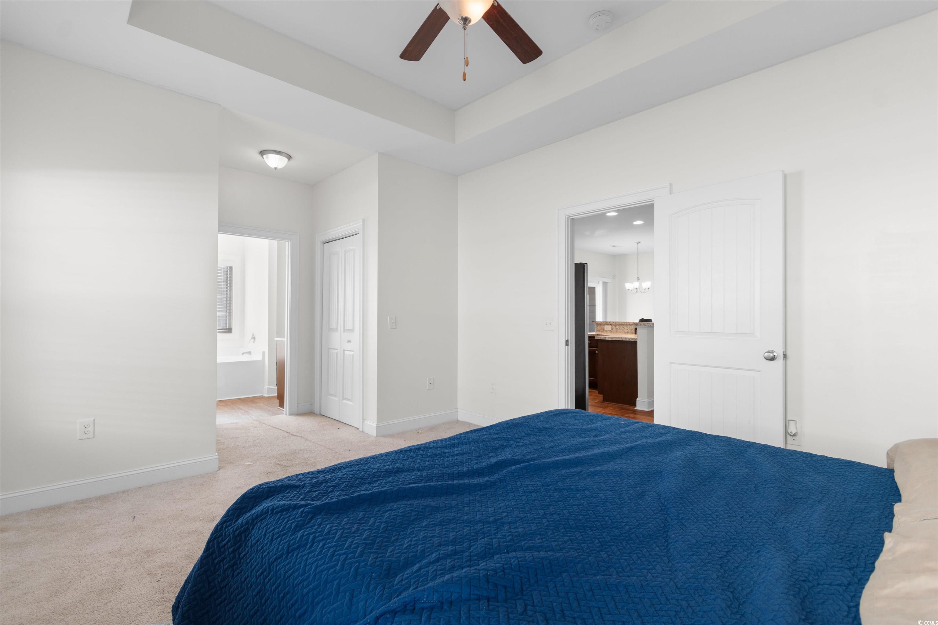 253 Maple Oak Drive Conway, SC 29526 - Photo 15 of 33 Bedroom with ensuite bathroom, light carpet, a tray ceiling, and a ceiling fan