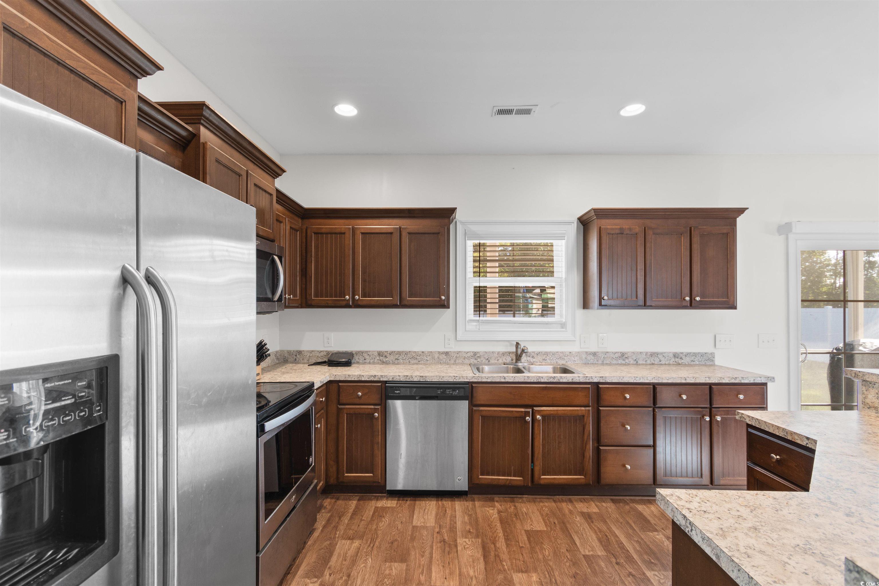 253 Maple Oak Drive Conway, SC 29526 - Photo 9 of 33 Kitchen with appliances with stainless steel finishes, dark wood-type flooring, recessed lighting, light countertops, and dark brown cabinets
