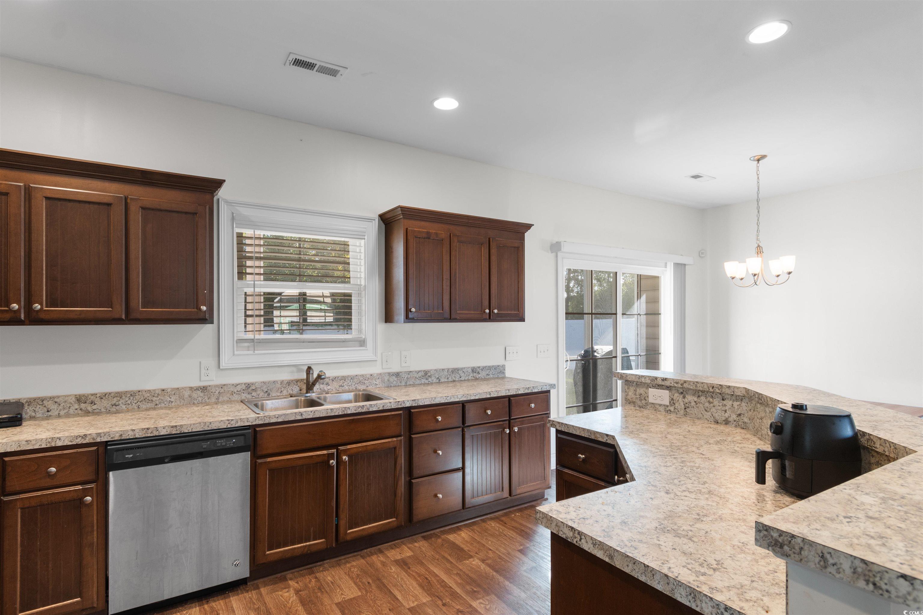 253 Maple Oak Drive Conway, SC 29526 - Photo 10 of 33 Kitchen with dishwasher, dark wood finished floors, recessed lighting, light countertops, and decorative light fixtures