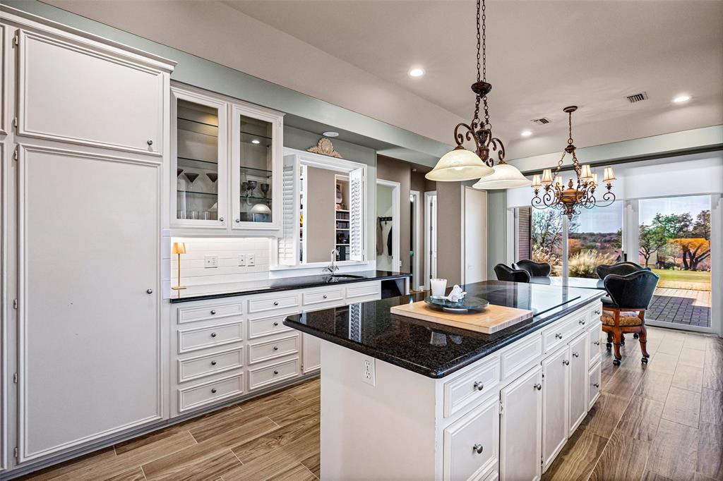8908 Brierfield Road Granbury, TX 76049 - Photo 14 of 40 a kitchen with a sink stove and wooden floor