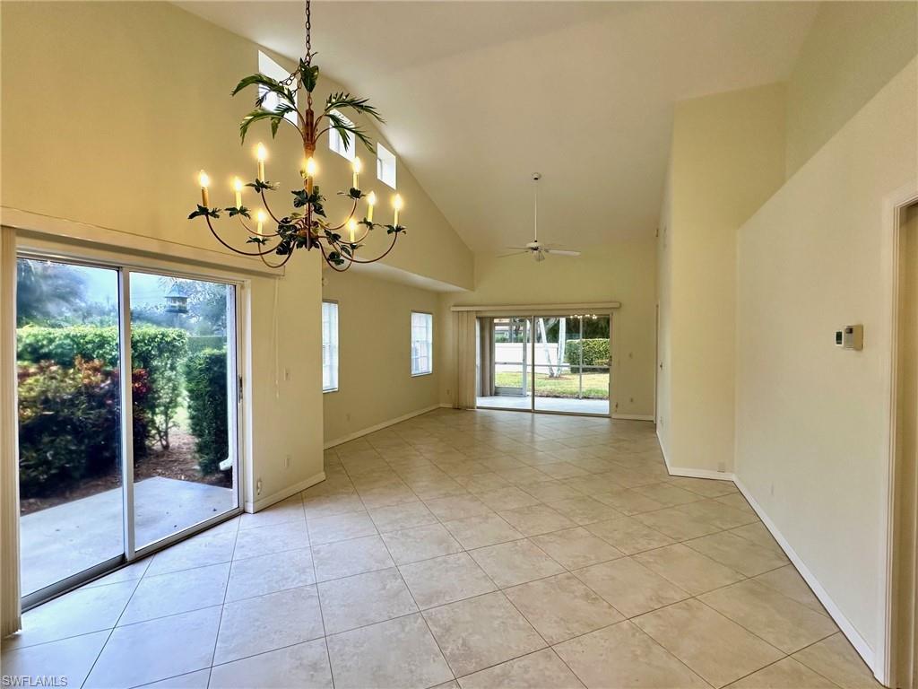 2525 Sailors Way, Unit 139 Naples, FL 34109 - Photo 7 of 20 Tiled empty room with ceiling fan with notable chandelier and high vaulted ceiling