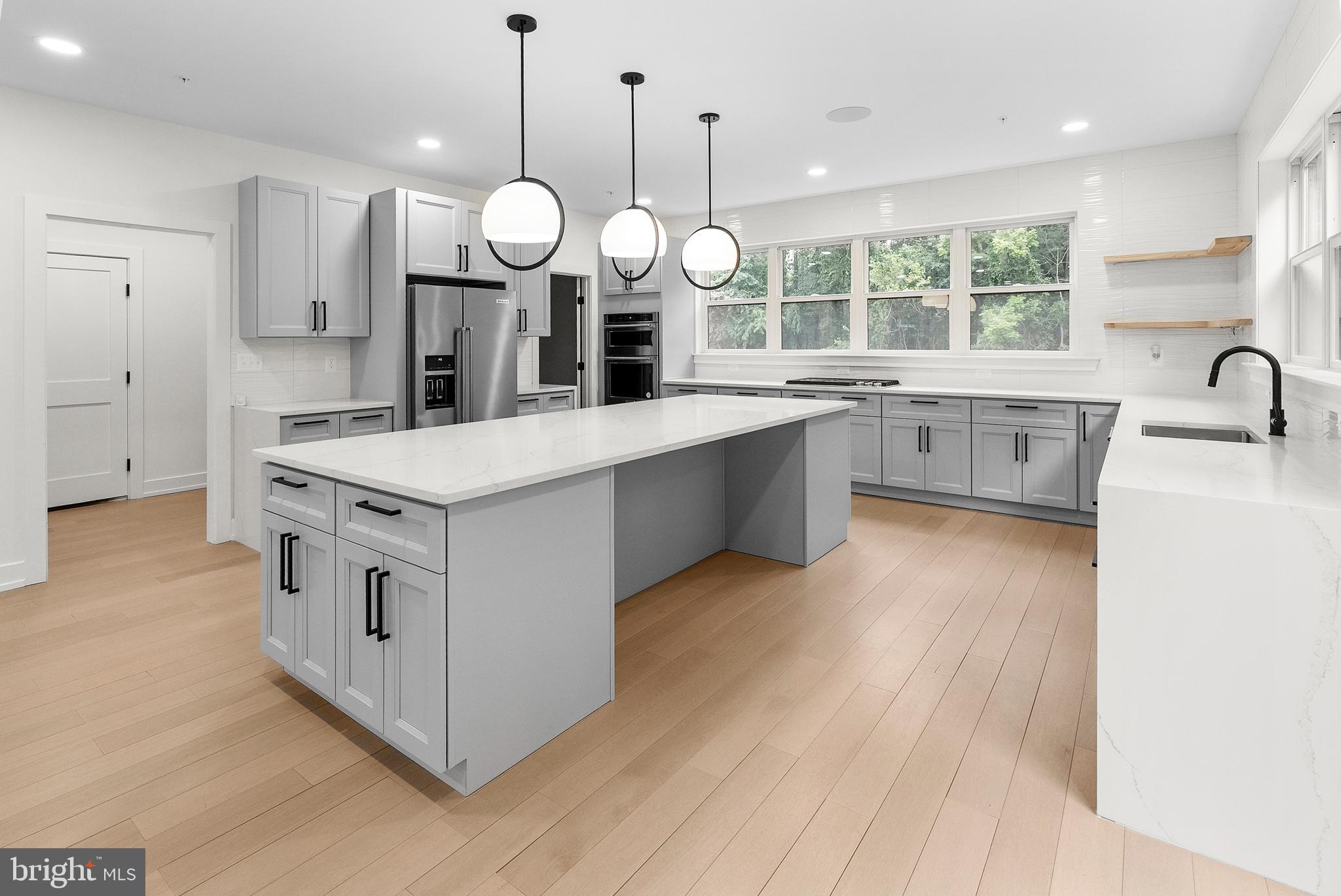 1321 Nicodemus Road Reisterstown, MD 21136 - Photo 6 of 30 a large white kitchen with a large island oven a stove couch and wooden floor