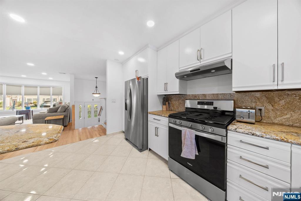 62 Sycamore Road Dumont, NJ 07628 - Photo 10 of 43 a kitchen with stainless steel appliances granite countertop a stove a refrigerator and a sink