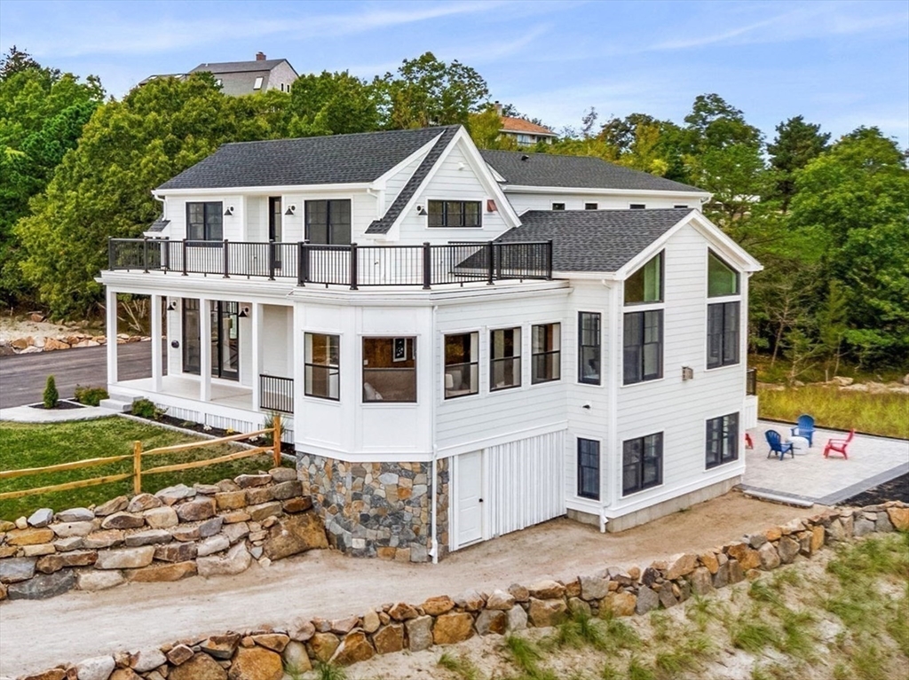 a view of a white house with a large windows next to a yard