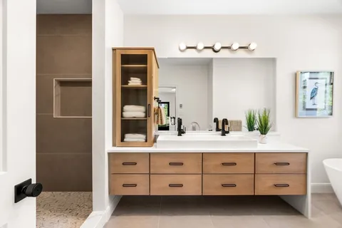 a bathroom with a double vanity sink mirror and shower