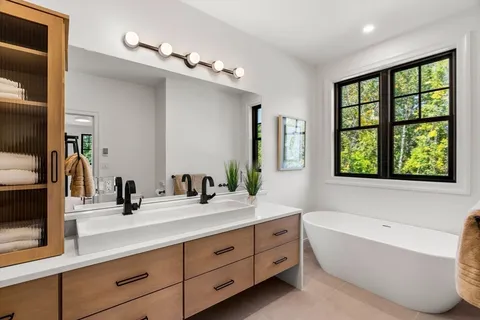 a bathroom with a large tub sink and mirror
