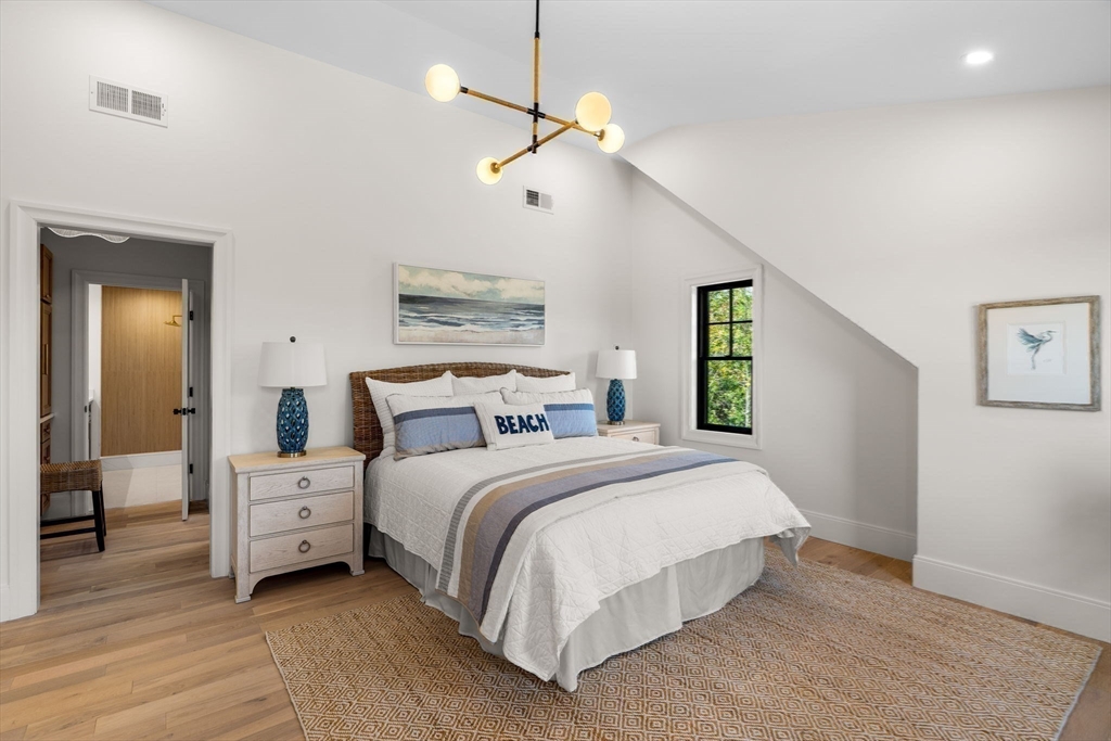 226 Atlantic Street Gloucester, MA 01930 - Photo 21 of 37 a bedroom with a large bed and a chandelier