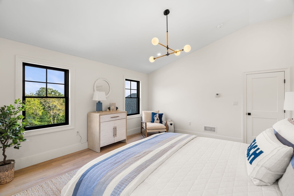 226 Atlantic Street Gloucester, MA 01930 - Photo 22 of 37 a bed room with a bed and a chandelier