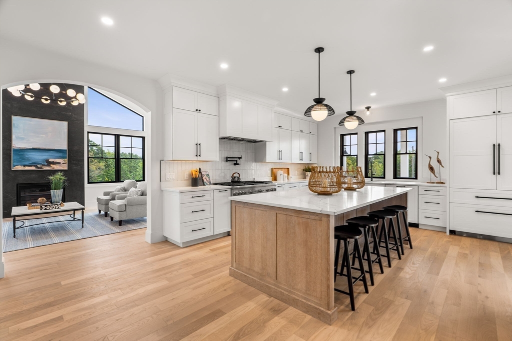 226 Atlantic Street Gloucester, MA 01930 - Photo 6 of 37 a kitchen with stainless steel appliances kitchen island granite countertop a stove a sink a refrigerator and white cabinets with wooden floor