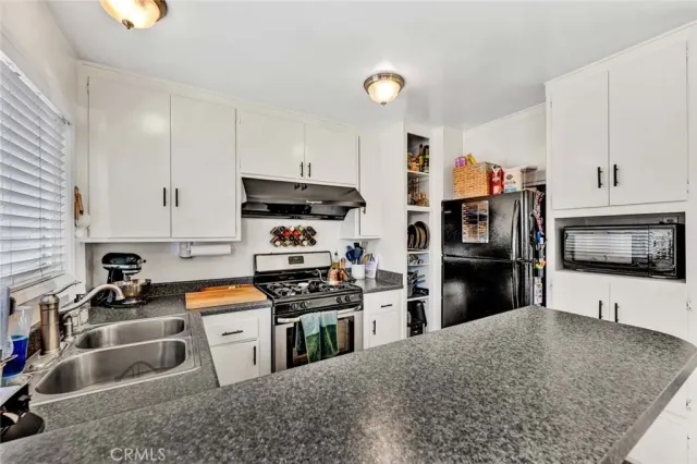 a kitchen with stainless steel appliances a sink a stove and a window