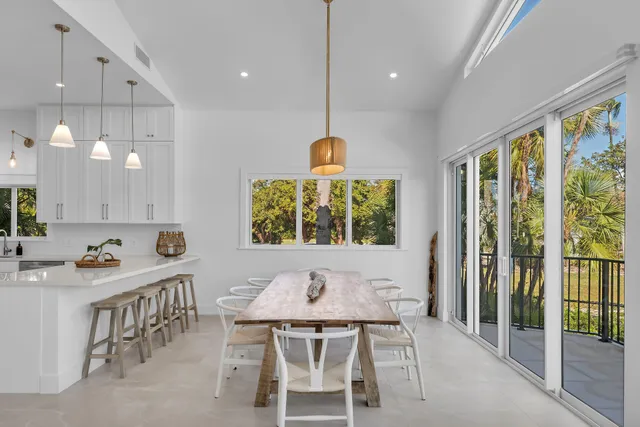 a kitchen with stainless steel appliances a sink a stove a refrigerator and white cabinets with wooden floor