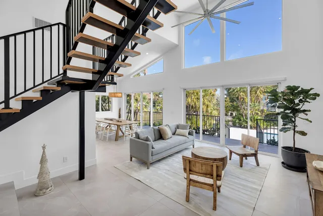 a living room with furniture a rug and a floor to ceiling window