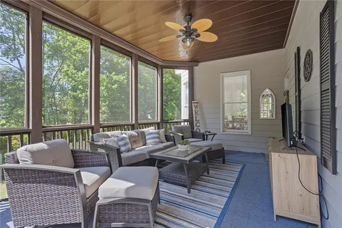 a living room with furniture a ceiling fan and a large window
