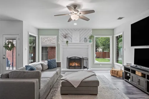 a living room with furniture a flat screen tv and a fireplace