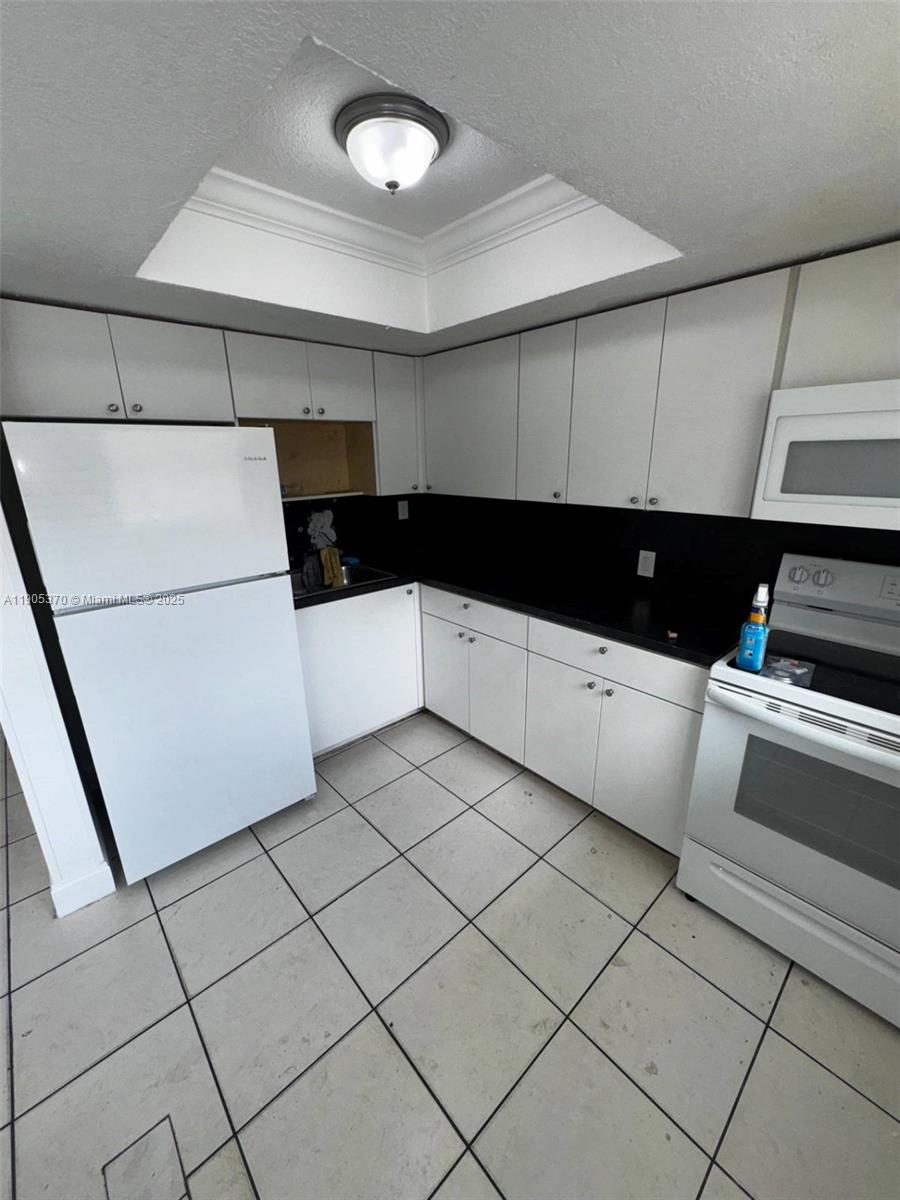 5150 West 12th Avenue, Unit 115 Hialeah, FL 33012 - Photo 5 of 14 a kitchen with a sink and white cabinets