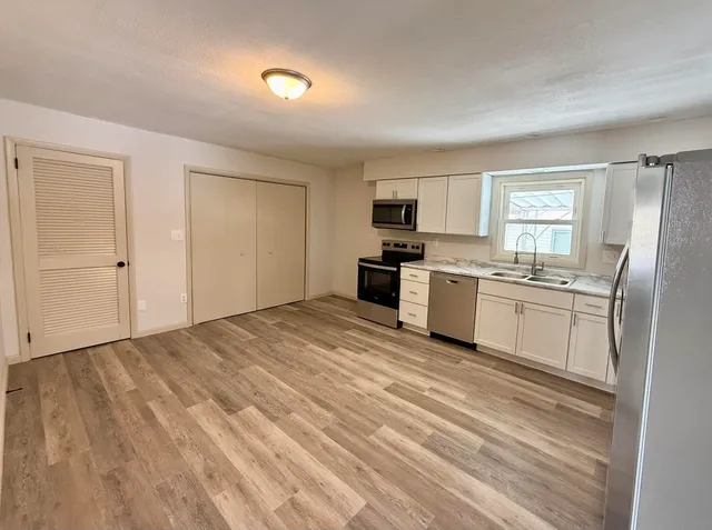a kitchen with stainless steel appliances a refrigerator sink and microwave