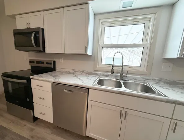 a view with a sink a microwave and window