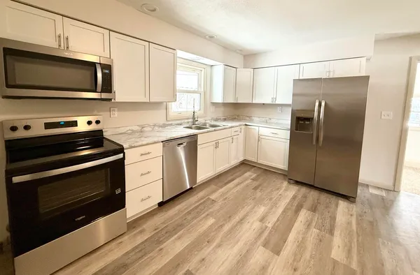 a kitchen with stainless steel appliances a stove microwave and sink