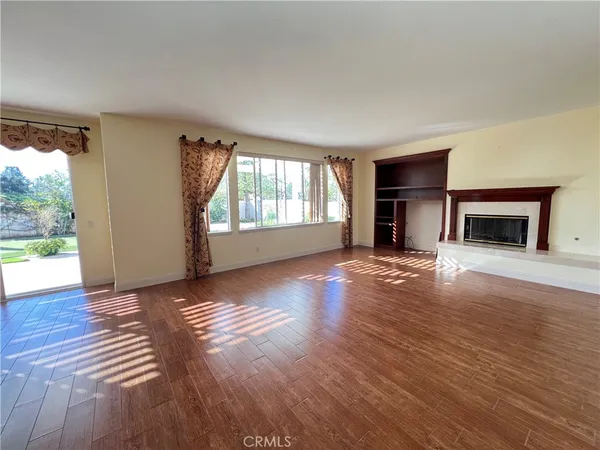 an empty room with windows and fireplace