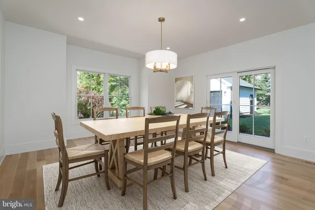 a dining room with furniture a chandelier and wooden floor
