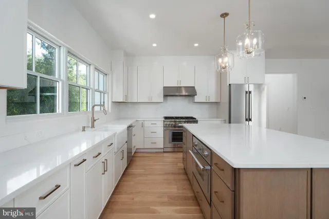 a kitchen with stainless steel appliances a sink stove and cabinets
