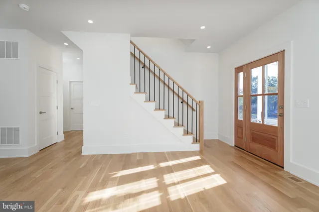a view of a hallway with wooden floor and staircase