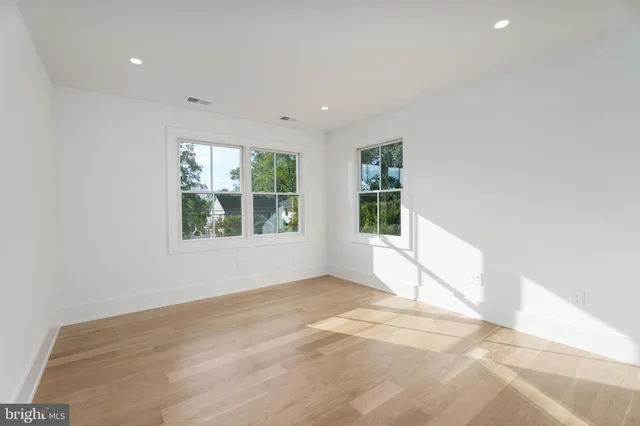 a bathroom with a toilet a sink a mirror a window and vanity
