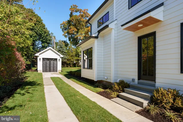 a view of a house with potted plants and a bench