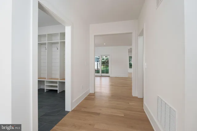a view of a hallway with wooden floor and closet