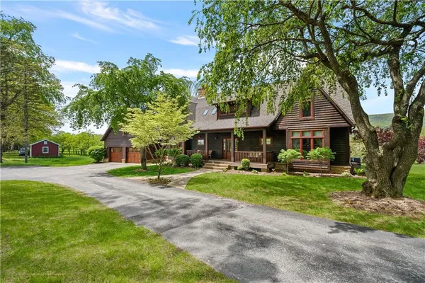 a front view of a house with a yard and trees